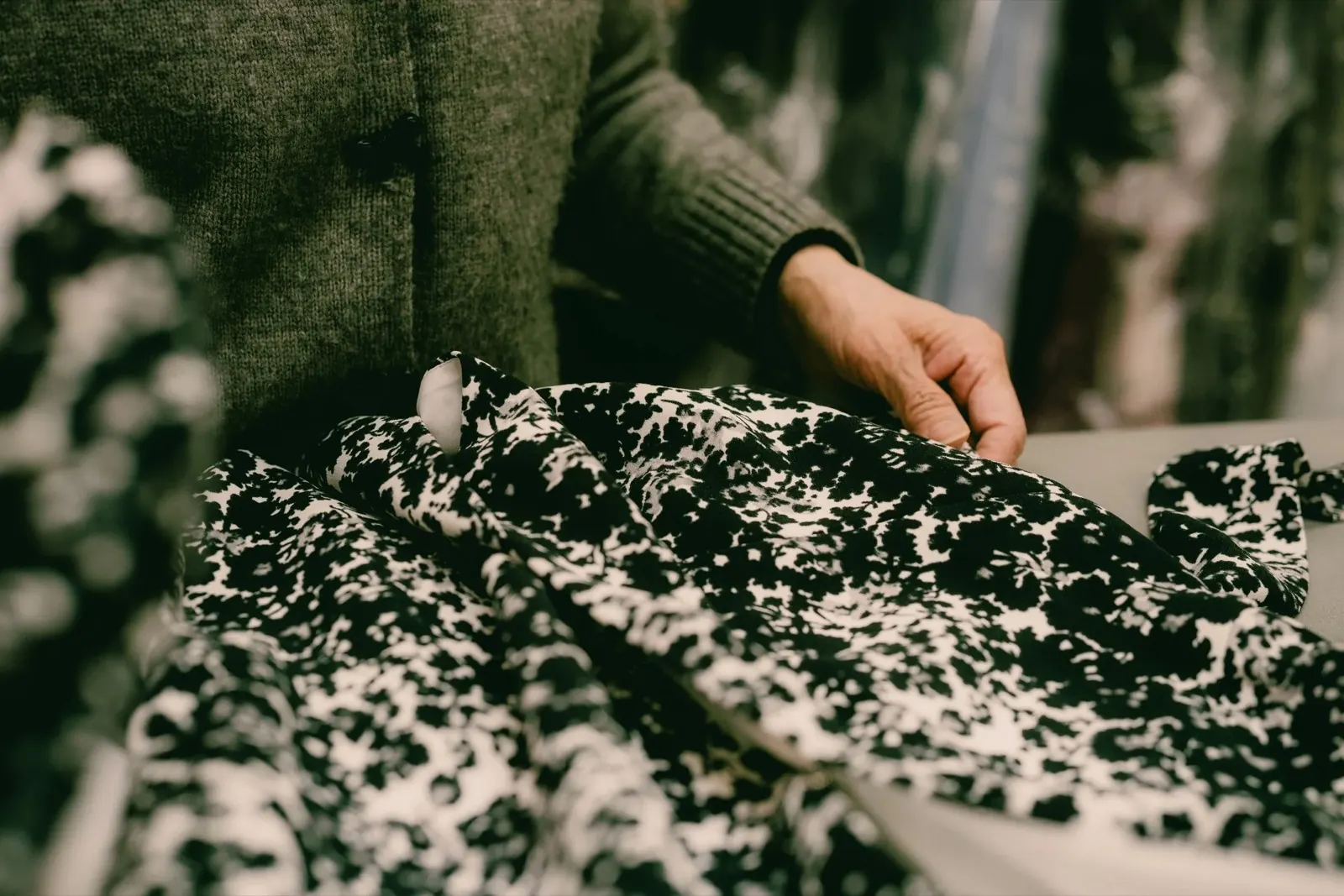 Hands smoothing patterned fabric before cutting