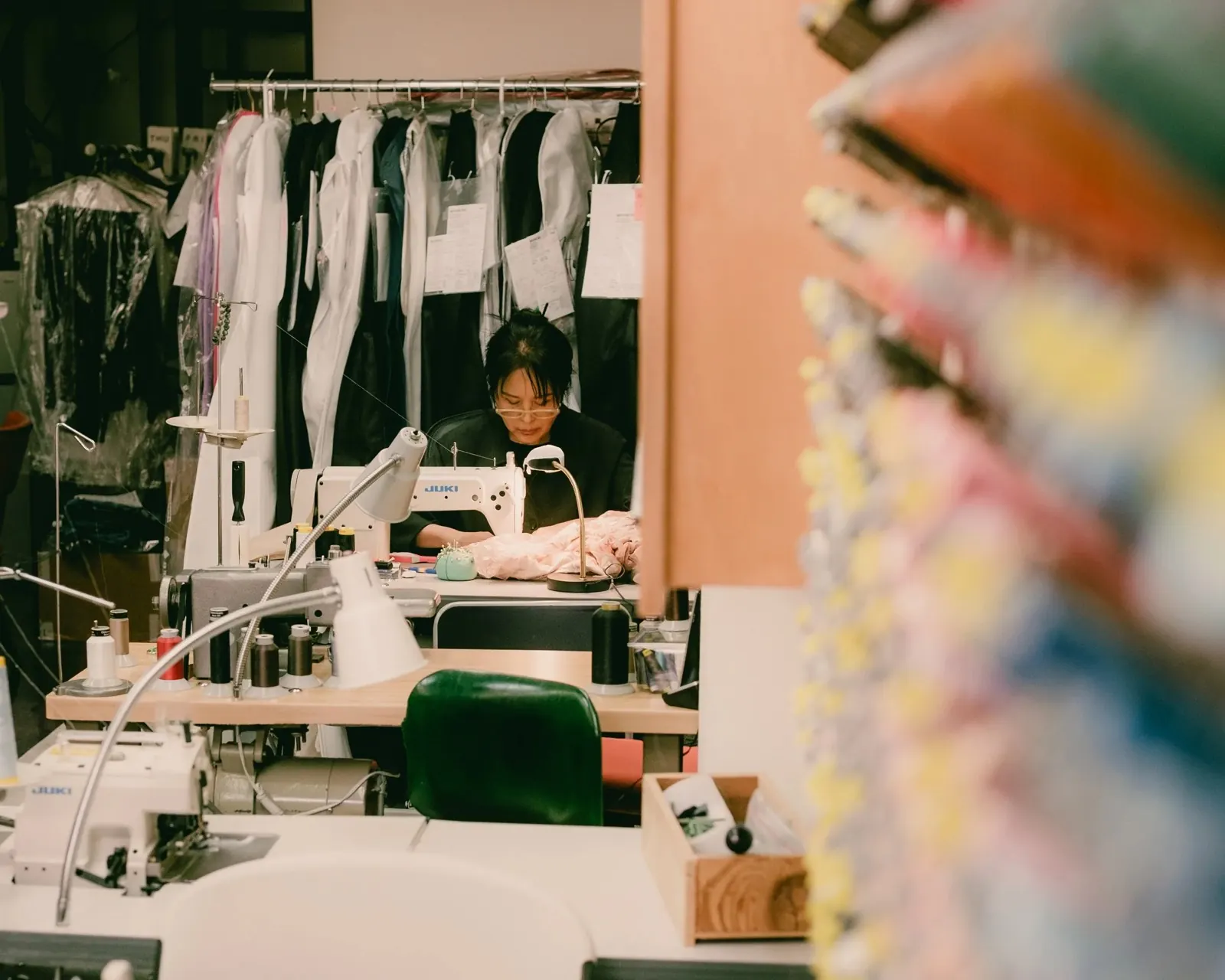 A tailor at work behind a sewing machine at Superb Custom Tailors